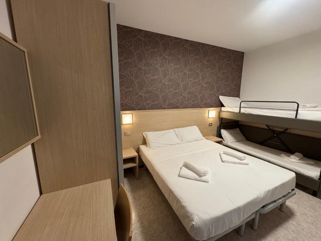Cette petite chambre comprend un lit et des lits superposés. dans l'établissement Residence le Spiagge, à Rimini