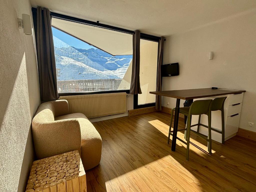 une pièce avec une table, une chaise et une fenêtre dans l'établissement Résidence Le Portillo, à Val Thorens