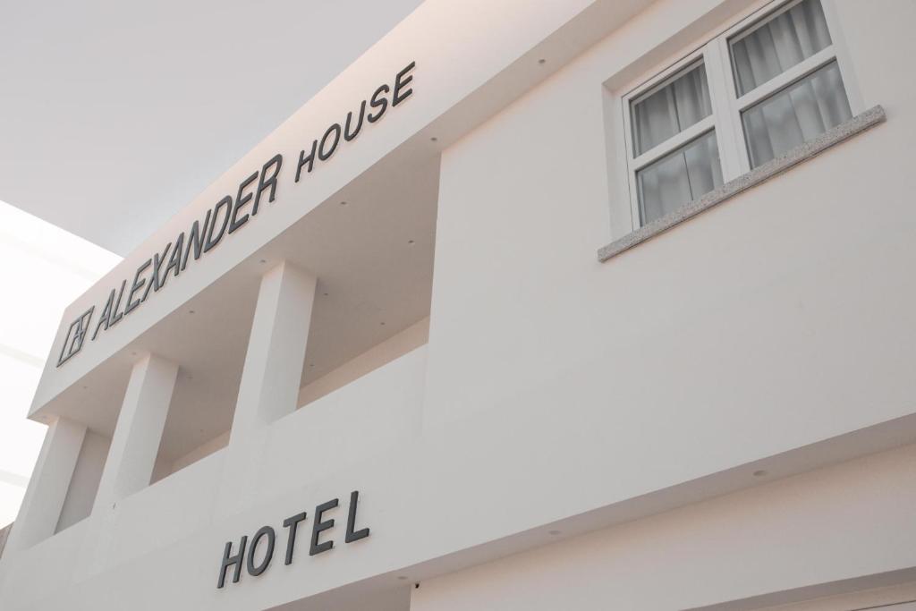 un bâtiment blanc avec une fenêtre sur le côté dans l'établissement Alexander House Hotel, à San Ferdinando