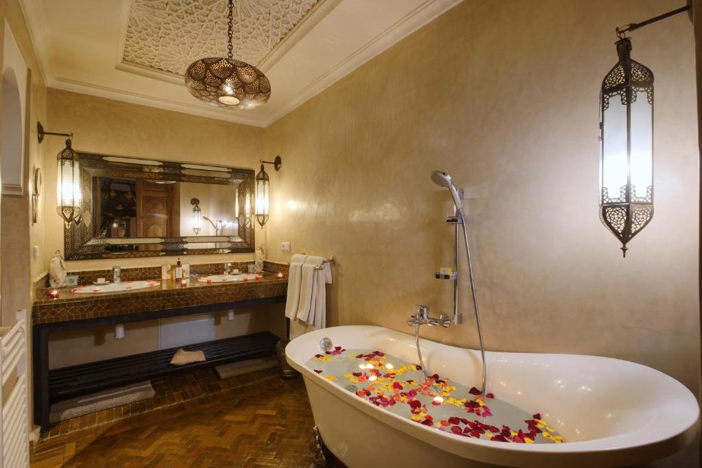 une salle de bain avec une baignoire et un grand miroir dans l'établissement Riad Kheirredine, à Marrakech