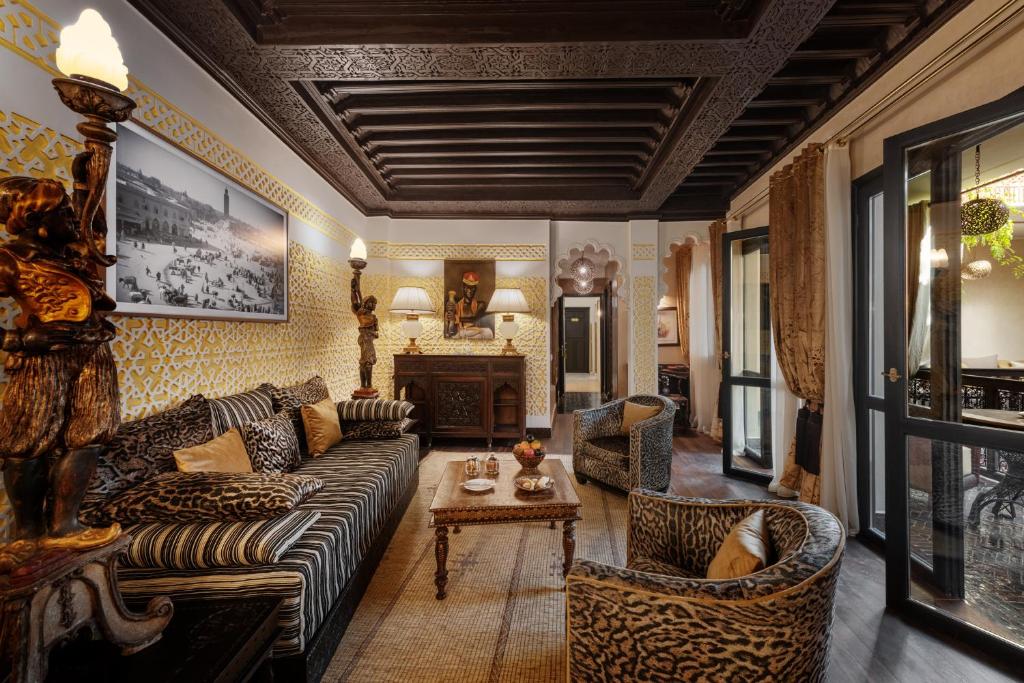 un salon avec un canapé, des chaises et une table dans l'établissement Riad Kheirredine, à Marrakech