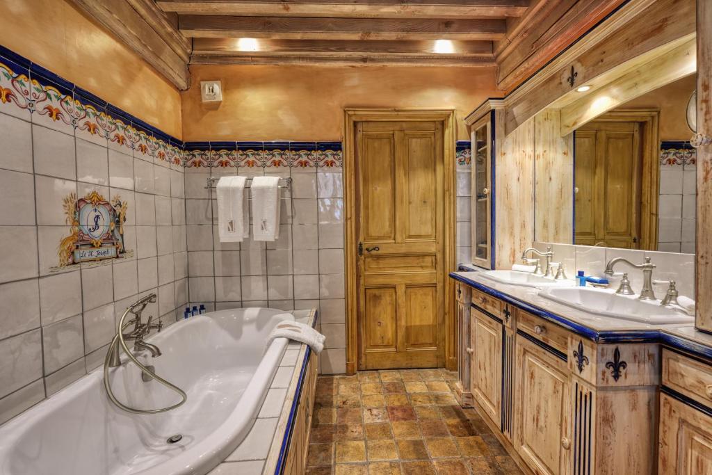 une grande salle de bain avec une baignoire et un lavabo dans l'établissement Le Saint Joseph, à Courchevel 33 autres photos