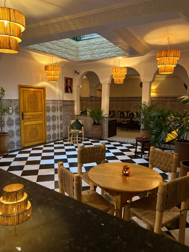 - un hall avec une table, des chaises et des lustres dans l'établissement Riad dar lakbira, à Marrakech