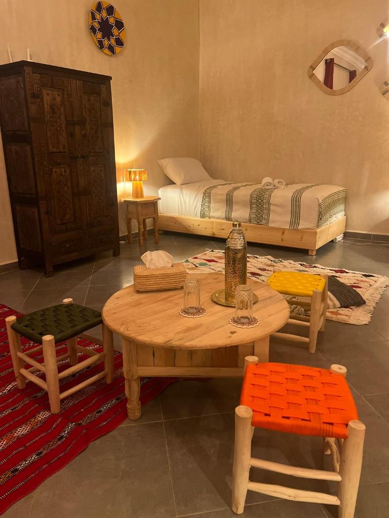 une pièce avec une table, des chaises et un lit dans l'établissement Riad dar lakbira, à Marrakech