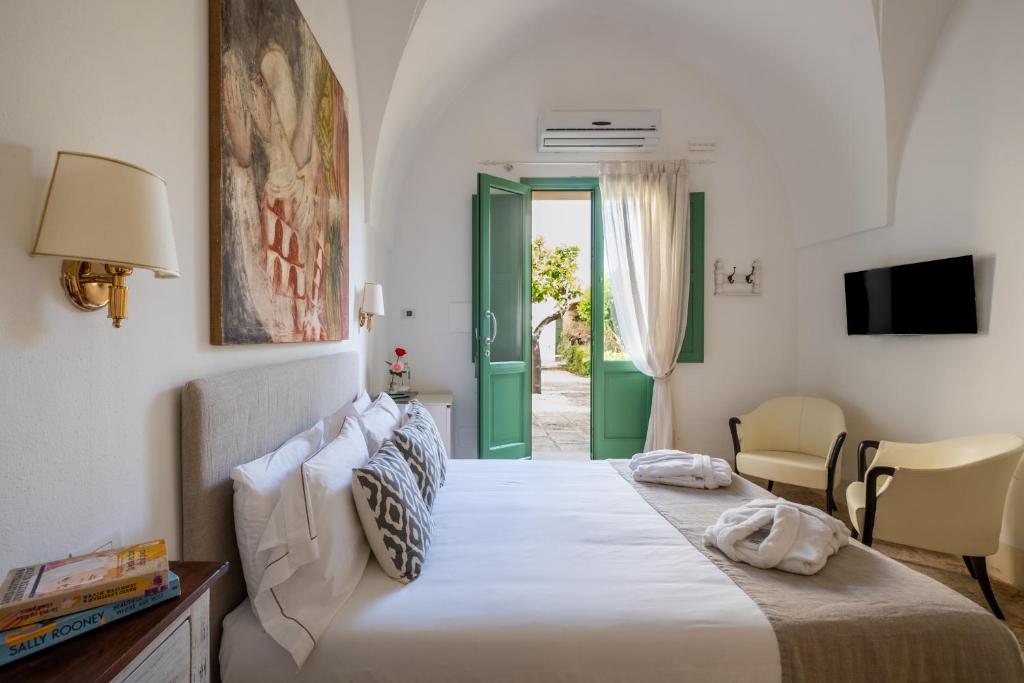 - une chambre avec un lit et une porte donnant sur une terrasse dans l'établissement Palazzo Ducale Venturi - Luxury Hotel & Wellness, à Minervino di Lecce