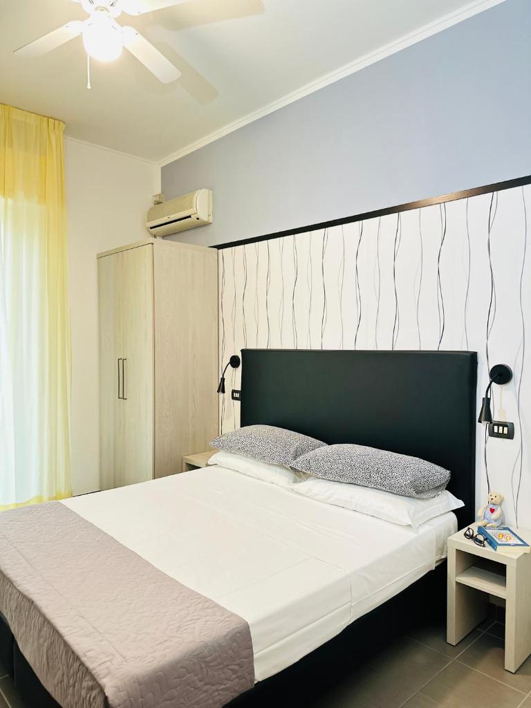 une chambre avec un grand lit avec une tête de lit verte dans l'établissement Hotel Villa Perazzini, à Rimini