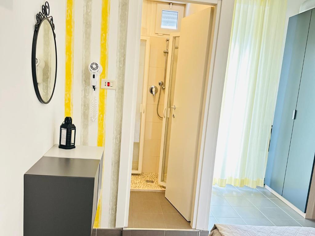 La salle de bains est pourvue d'une douche et d'un miroir mural. dans l'établissement Hotel Villa Perazzini, à Rimini 48 autres photos
