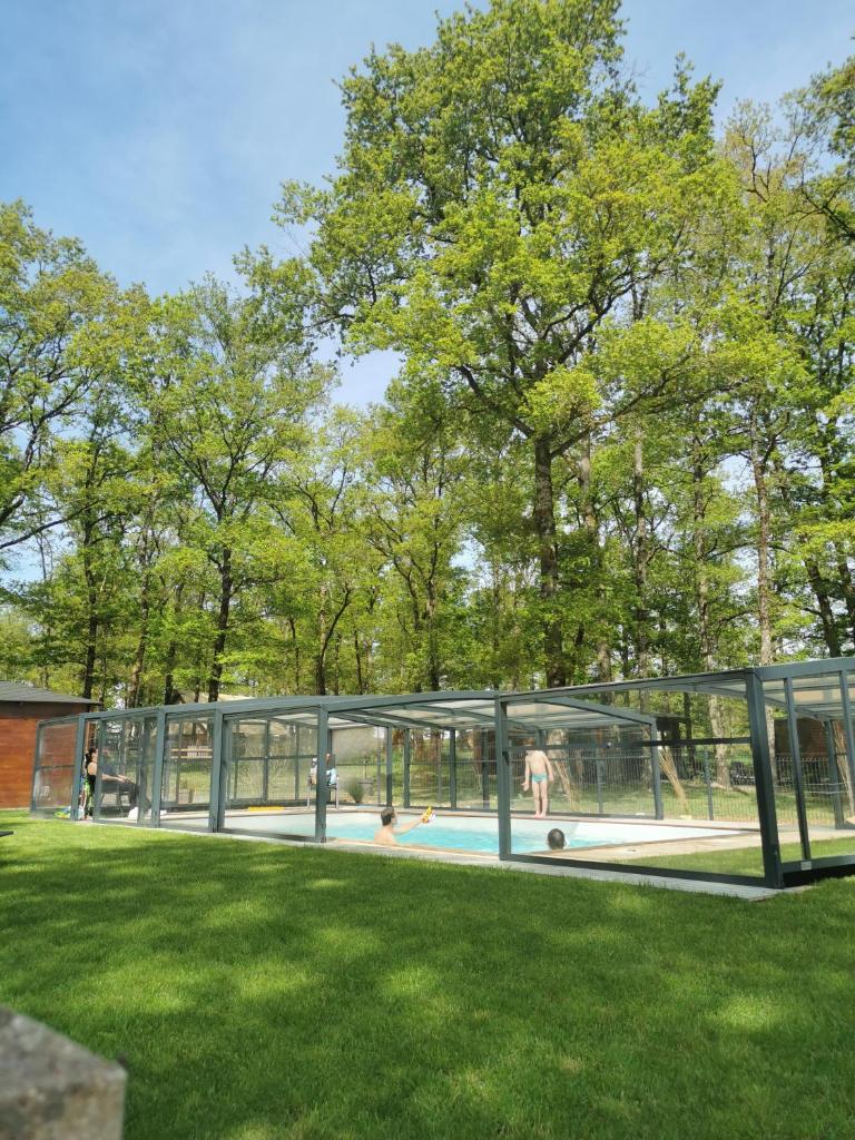 une maison en verre avec une piscine dans une cour dans l'établissement La Parenthèse Meslandaise, à Mesland