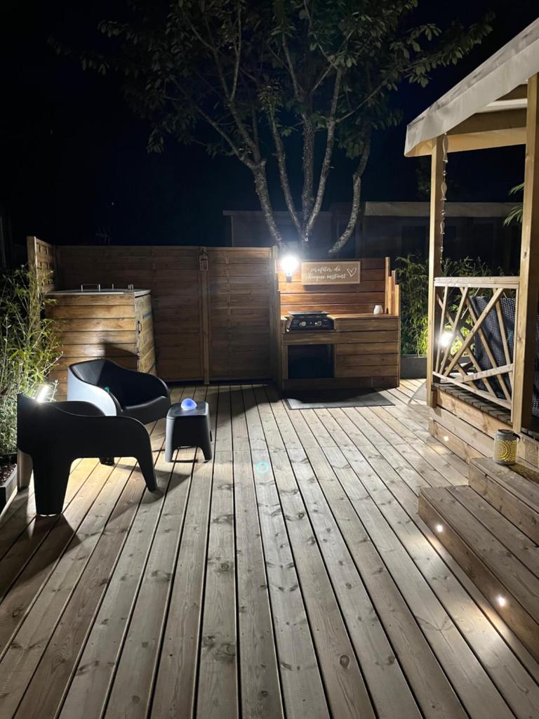 - une terrasse en bois la nuit dans l'établissement Mobil home climatisé au calme et proche des activités LEGE CAP FERRET, à Lège-Cap-Ferret
