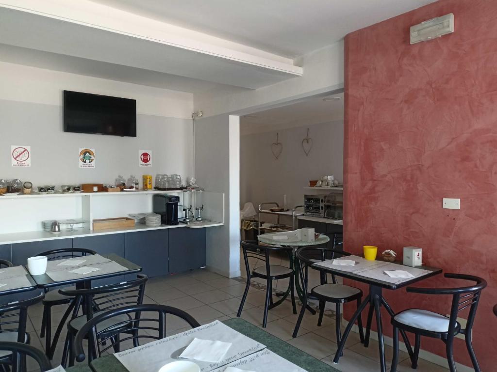 un restaurant avec des tables et des chaises et une cuisine dans l'établissement Hotel Ariston Imperial, à Porto Garibaldi