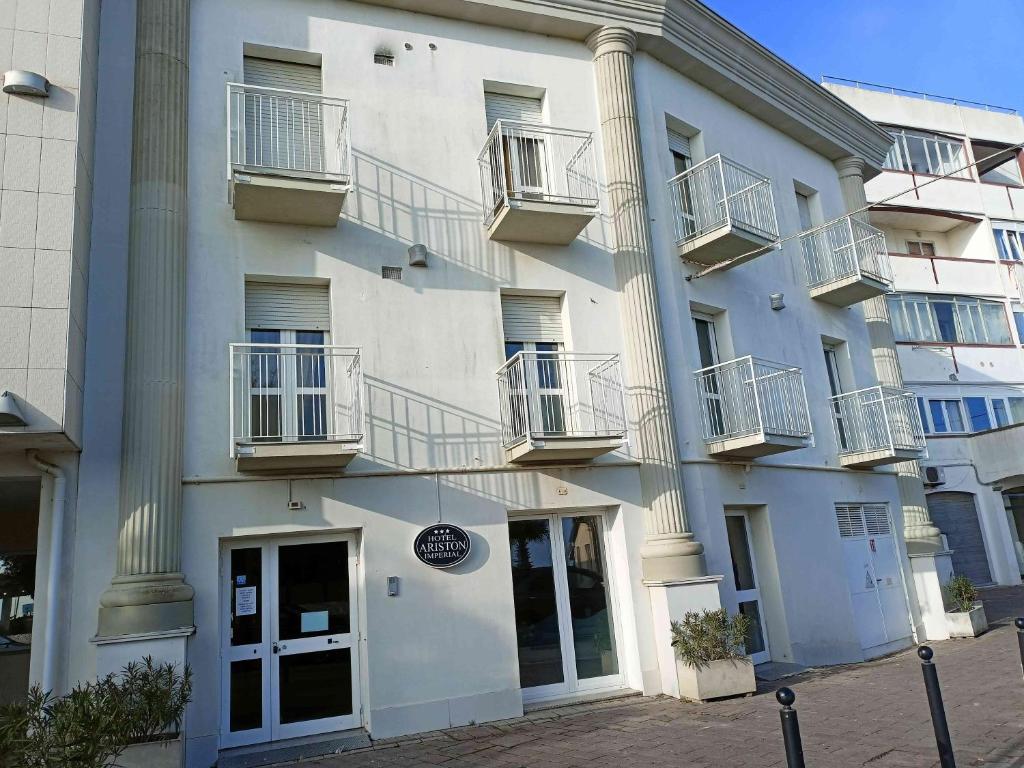 un bâtiment blanc avec des balcons sur le côté dans l'établissement Hotel Ariston Imperial, à Porto Garibaldi