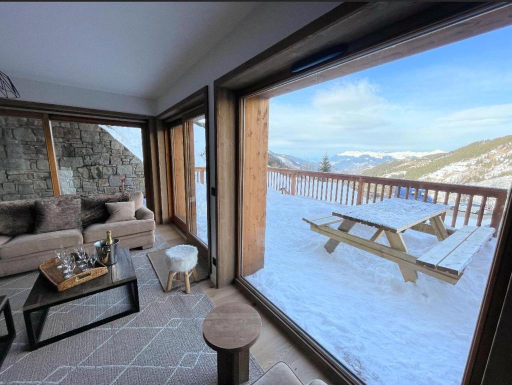 - un salon avec vue sur une table de pique-nique dans l'établissement Les Chalets A11 Meribel, spacious family duplex, 100m from ski lift Les Chalets, à Méribel