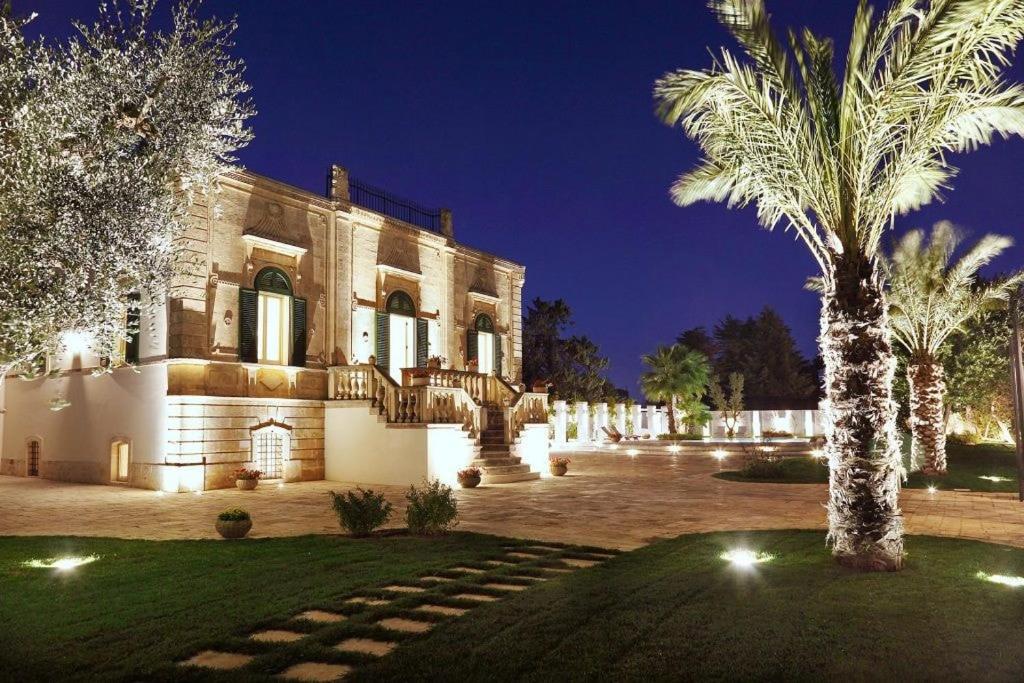 une grande maison avec un palmier en face dans l'établissement Villa Favorita Luxury - Italia Monopoli Puglia Trullo, à Monopoli