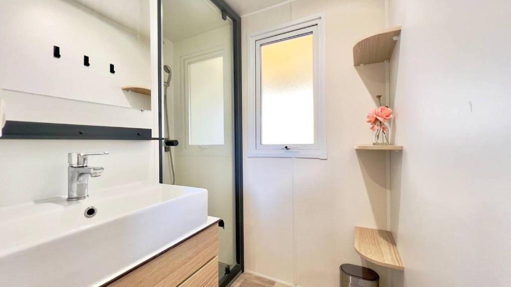une salle de bain blanche avec un lavabo et une fenêtre dans l'établissement Mobil-Home Les Lauriers Roses Camping Siblu 4****, à Fréjus