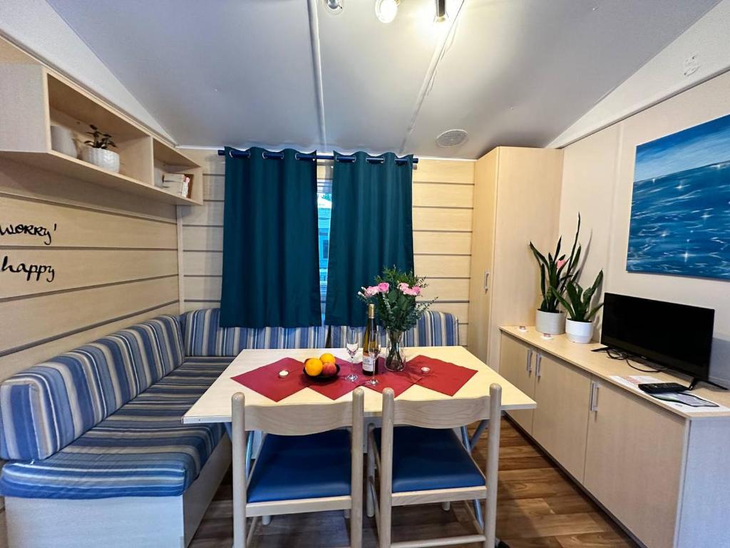 une petite salle à manger avec une table et un bureau dans l'établissement Sweet Mobile home near Europapark, à Boofzheim
