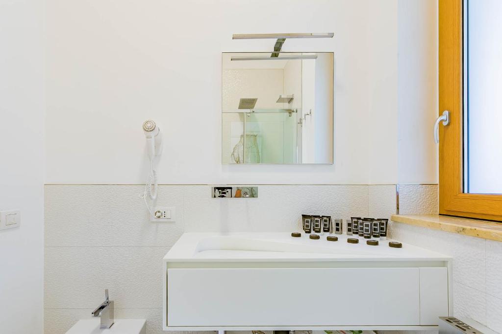 une salle de bain avec un lavabo blanc et un miroir dans l'établissement Villa Incanto nel Blu by Wonderful Italy, à Polignano a Mare