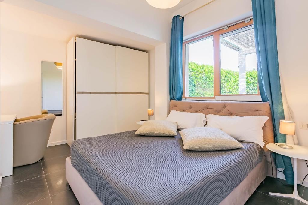 - une chambre avec un lit doté de rideaux bleus et d'une fenêtre dans l'établissement Villa Incanto nel Blu by Wonderful Italy, à Polignano a Mare