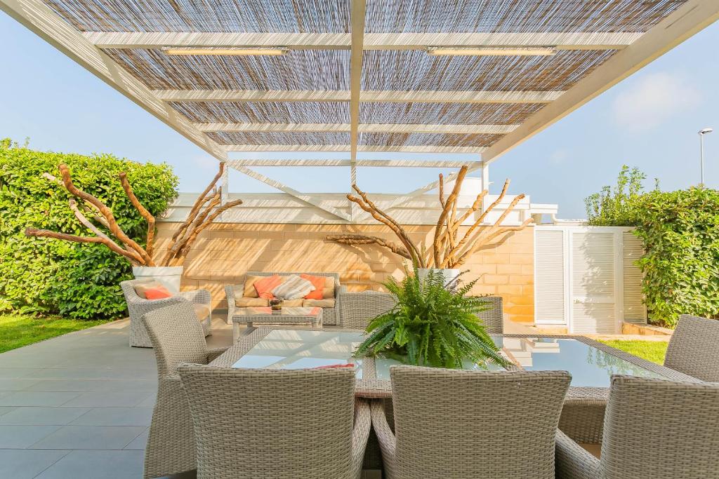 d'une terrasse avec une table et des chaises ainsi qu'un toit. dans l'établissement Villa Incanto nel Blu by Wonderful Italy, à Polignano a Mare