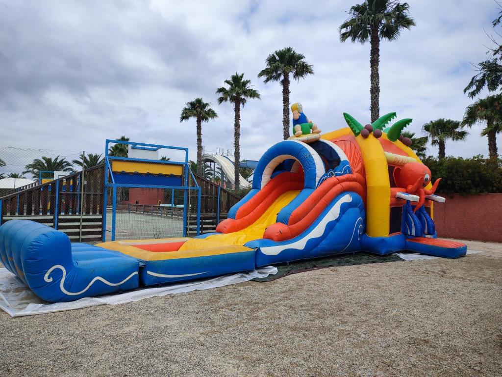 - un toboggan aquatique dans une aire de jeux dans un parc dans l'établissement Grand MOBIL HOME Spatieux 40m2 - 2 Ch, à Argelès-sur-Mer