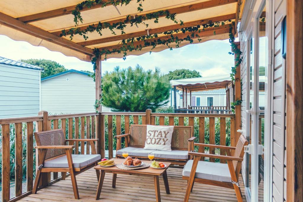 un patio avec deux chaises et une table sur une terrasse dans l'établissement Dreamy Lodge - Plaisir & Plage à 100m, à Canet