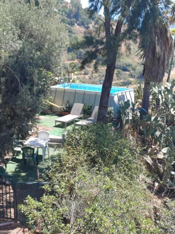 une arrière-cour avec une maison et une piscine dans l'établissement Casa il Faro villa con piscina, à Castelmola