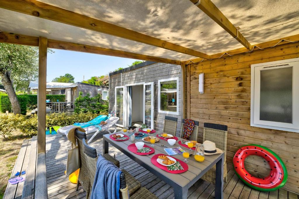 une table et des chaises sur une terrasse en bois dans l'établissement Domaine Résidentiel de Plein Air Le Bois d'Amour, à Quiberon
