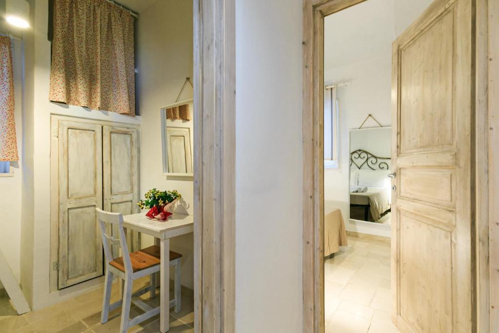 Cette chambre dispose d'une petite table et d'une porte. dans l'établissement Le Dimore di Trulli Mandorlo con piscina esclusiva, à Putignano