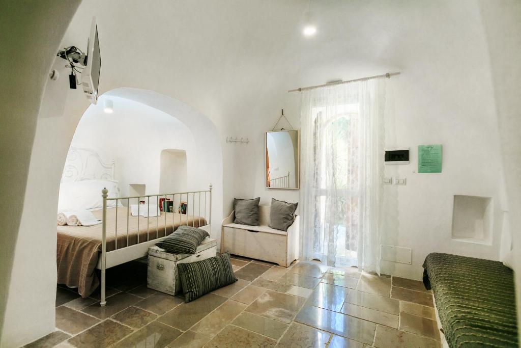 une chambre blanche avec un lit et une fenêtre dans l'établissement Le Dimore di Trulli Mandorlo con piscina esclusiva, à Putignano