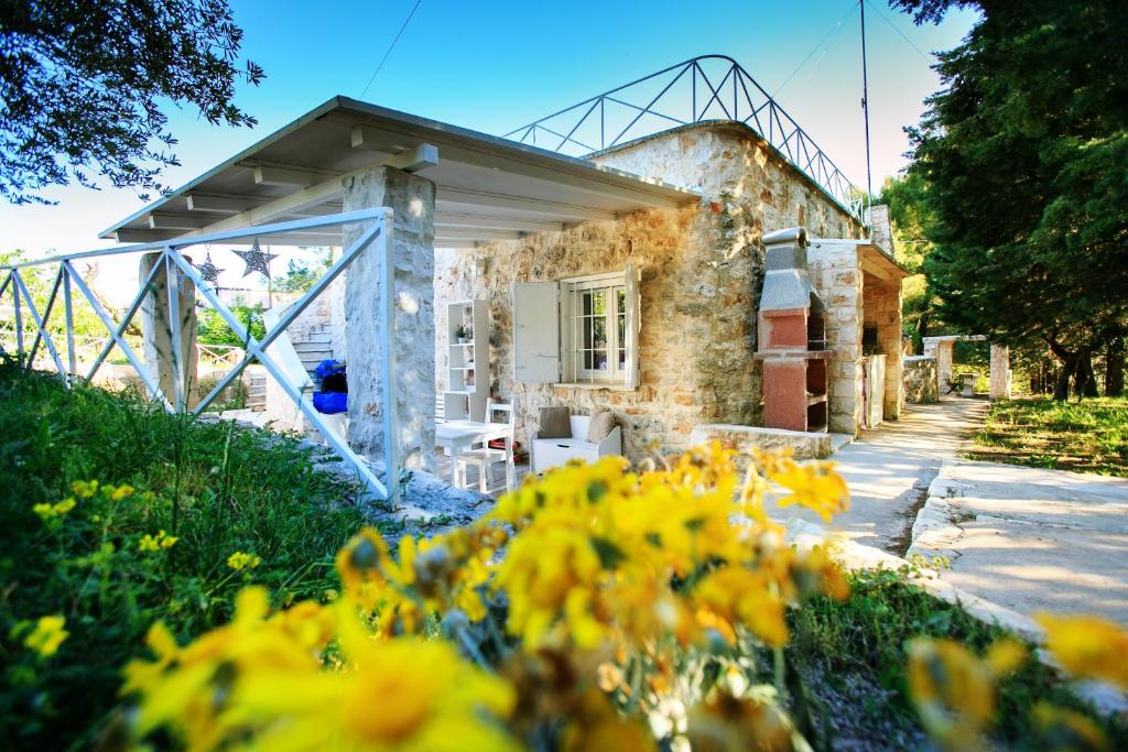 une maison en pierre avec des fleurs devant dans l'établissement Le Dimore di Trulli Mandorlo con piscina esclusiva, à Putignano