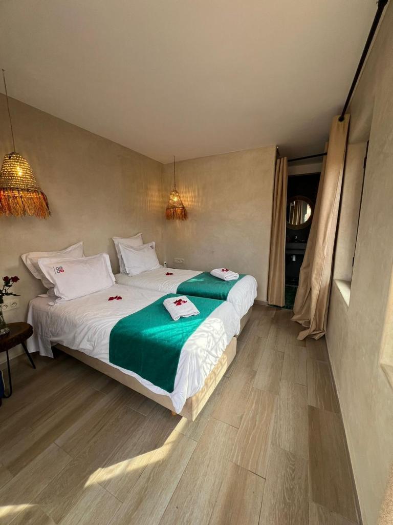 une chambre avec un grand lit avec des draps verts dans l'établissement Riad Vendôme & Spa, à Marrakech