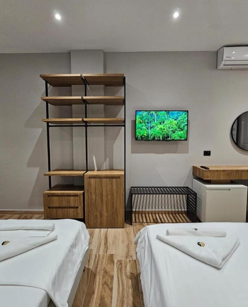 une chambre avec deux lits et une télévision au mur dans l'établissement Hotel Levante Cesenatico, à Cesenatico