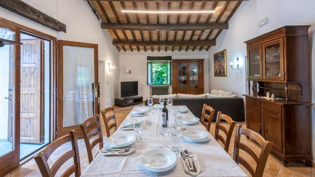 une salle à manger avec une longue table et des chaises dans l'établissement Palazzo Ducale Urbino - Villa con Piscina, à Stazione delle Pole-Piobbico