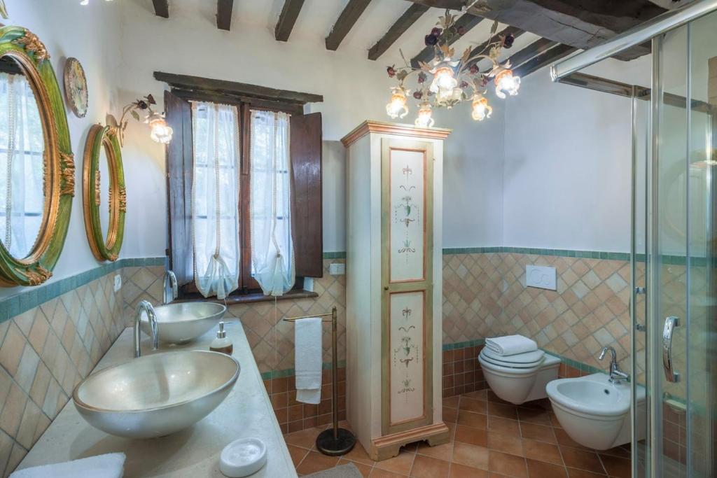 une salle de bain avec deux lavabos et un WC dans l'établissement Palazzo Ducale Urbino - Villa con Piscina, à Stazione delle Pole-Piobbico 33 autres photos