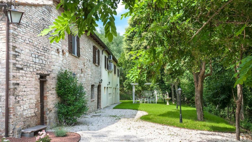 une maison en pierre avec un chemin menant à une cour dans l'établissement Palazzo Ducale Urbino - Villa con Piscina, à Stazione delle Pole-Piobbico