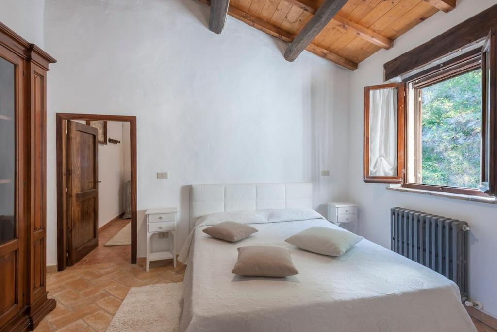 une chambre avec un grand lit blanc avec deux oreillers dans l'établissement Palazzo Ducale Urbino - Villa con Piscina, à Stazione delle Pole-Piobbico