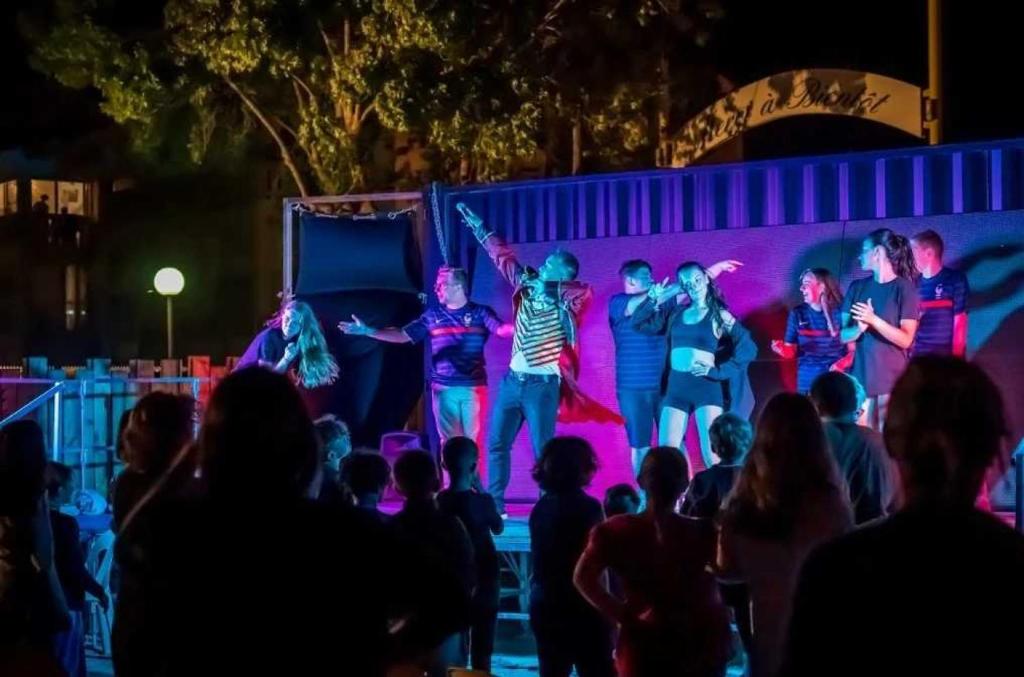 Un groupe de personnes sur une scène avec une foule dans l'établissement Camping - Parc aquatique - ccahfai, à Argelès-sur-Mer
