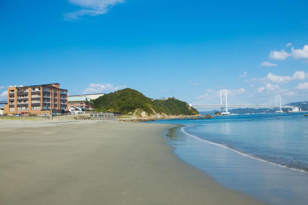 - une vue sur la plage avec un pont en arrière-plan dans l'établissement Seaside Hotel Taimaru Kaigetsu, à Naruto