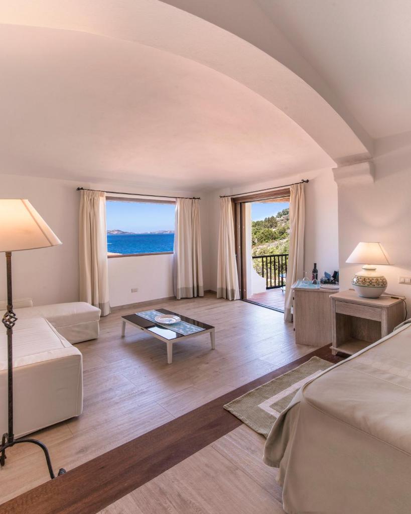 - un grand salon avec vue sur l'océan dans l'établissement Hotel La Bisaccia, à Baja Sardinia
