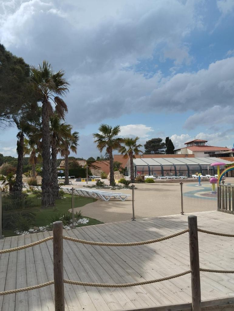 une clôture de cordes avec des palmiers et un bâtiment dans l'établissement Entre mer et montagne, à Canet
