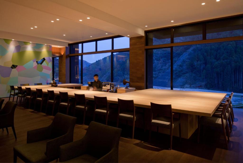 une grande salle de conférence avec une longue table et des chaises dans l'établissement Furuyu Onsen Oncri, à Saga