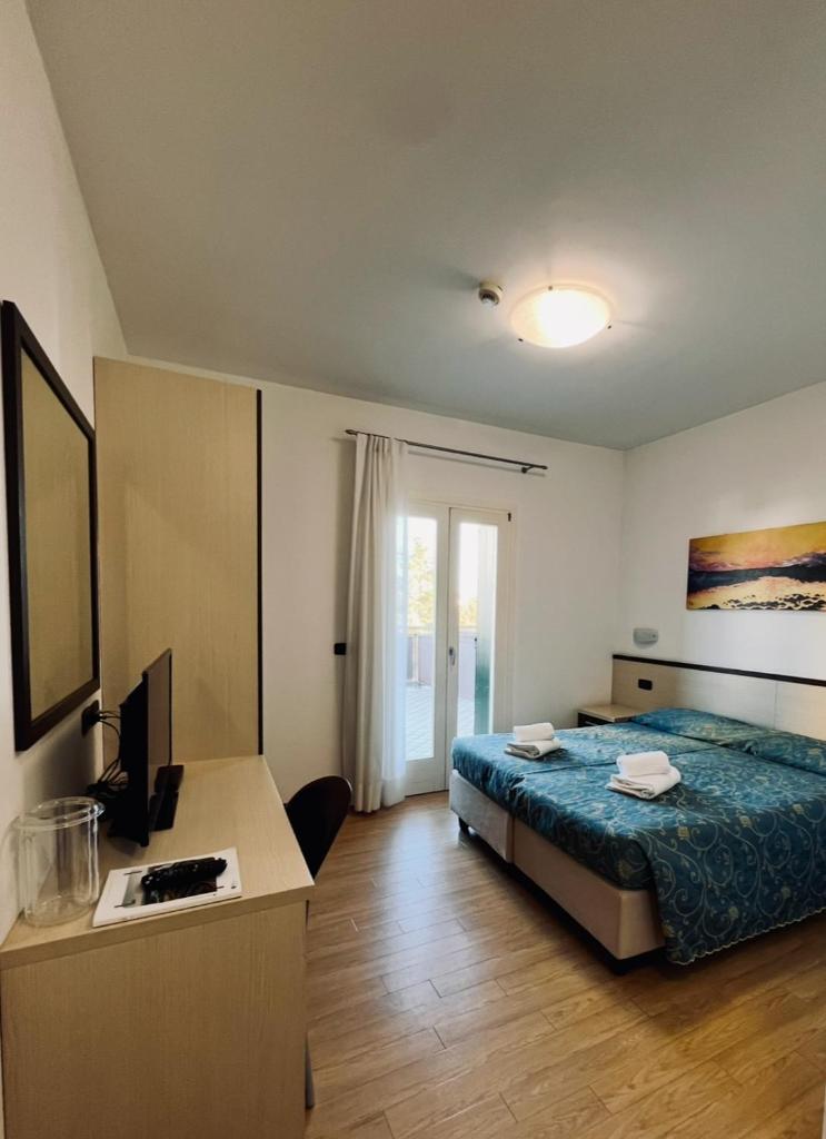 une chambre avec un lit et un bureau avec un ordinateur dans l'établissement Hotel Al Fogo, à Bevazzana