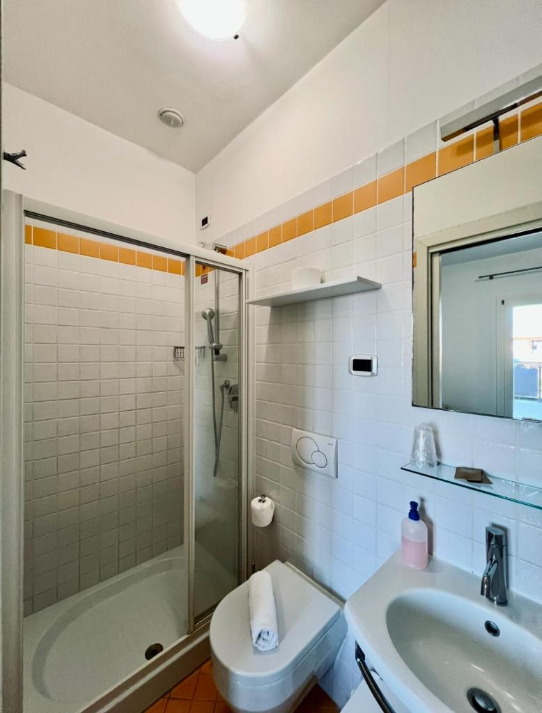 une salle de bain avec douche, lavabo et toilettes dans l'établissement Hotel Al Fogo, à Bevazzana