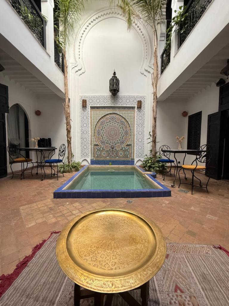 - une piscine dans une cour avec une table et des chaises dans l'établissement Dar Fangui, à Marrakech