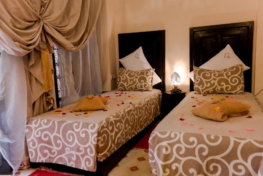 - une chambre avec 2 lits fleuris dans l'établissement Riad Hôtel Marraplace, à Marrakech