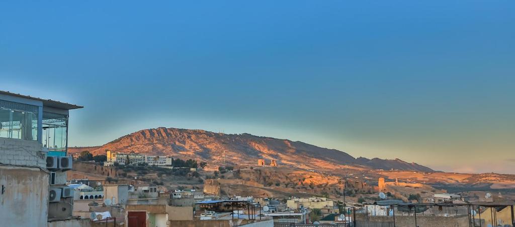 une vue d'une ville avec une montagne en arrière-plan dans l'établissement Riad Nayum, à Fès