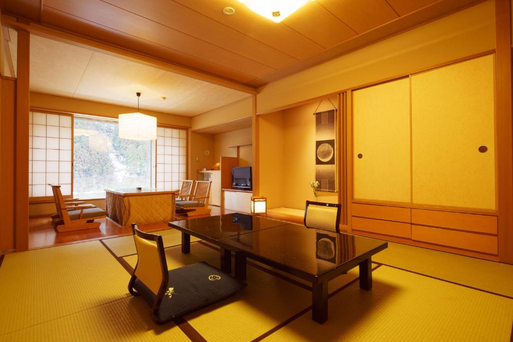 un salon avec une table et une chaise dans l'établissement Shogawa Onsen Yumetsuzuri, à Tonami