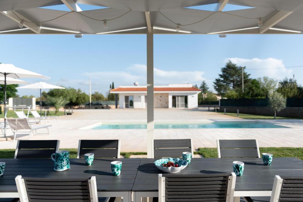 une table noire avec des chaises et un parasol dans l'établissement CHIALE Holiday Villa, à Polignano a Mare