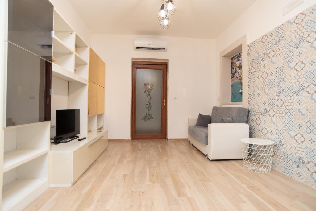 un salon avec un canapé et une télévision dans l'établissement CHIALE Holiday Villa, à Polignano a Mare