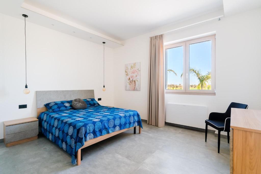 une chambre avec un lit, un bureau et une fenêtre dans l'établissement Villa Red Wind by Perle di Puglia, à Nardò