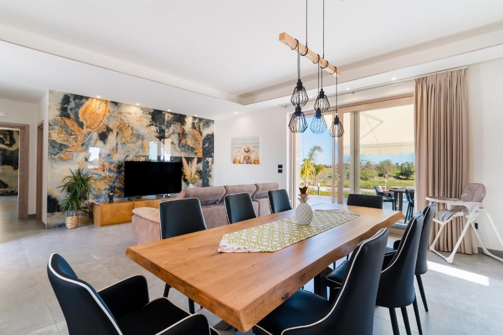 - une salle à manger et un salon avec une table et des chaises en bois dans l'établissement Villa Red Wind by Perle di Puglia, à Nardò